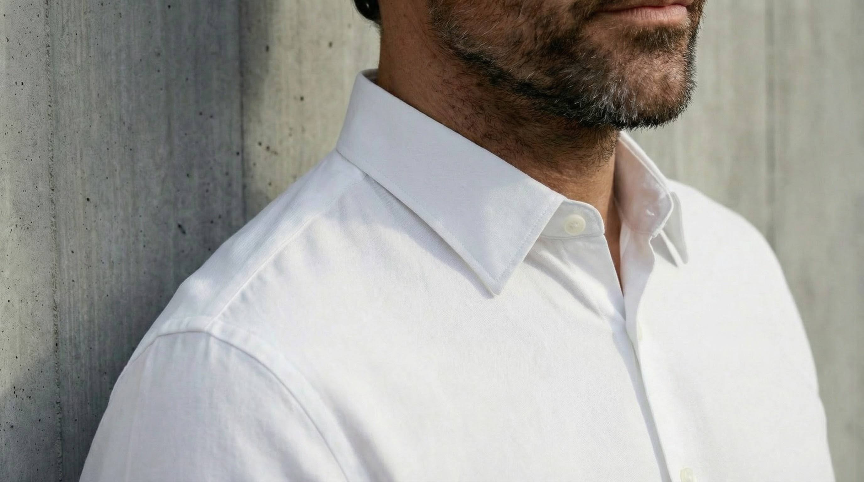 Gros plan sur le col structuré d’une chemise blanche stretch pour homme, coupe nette et moderne.