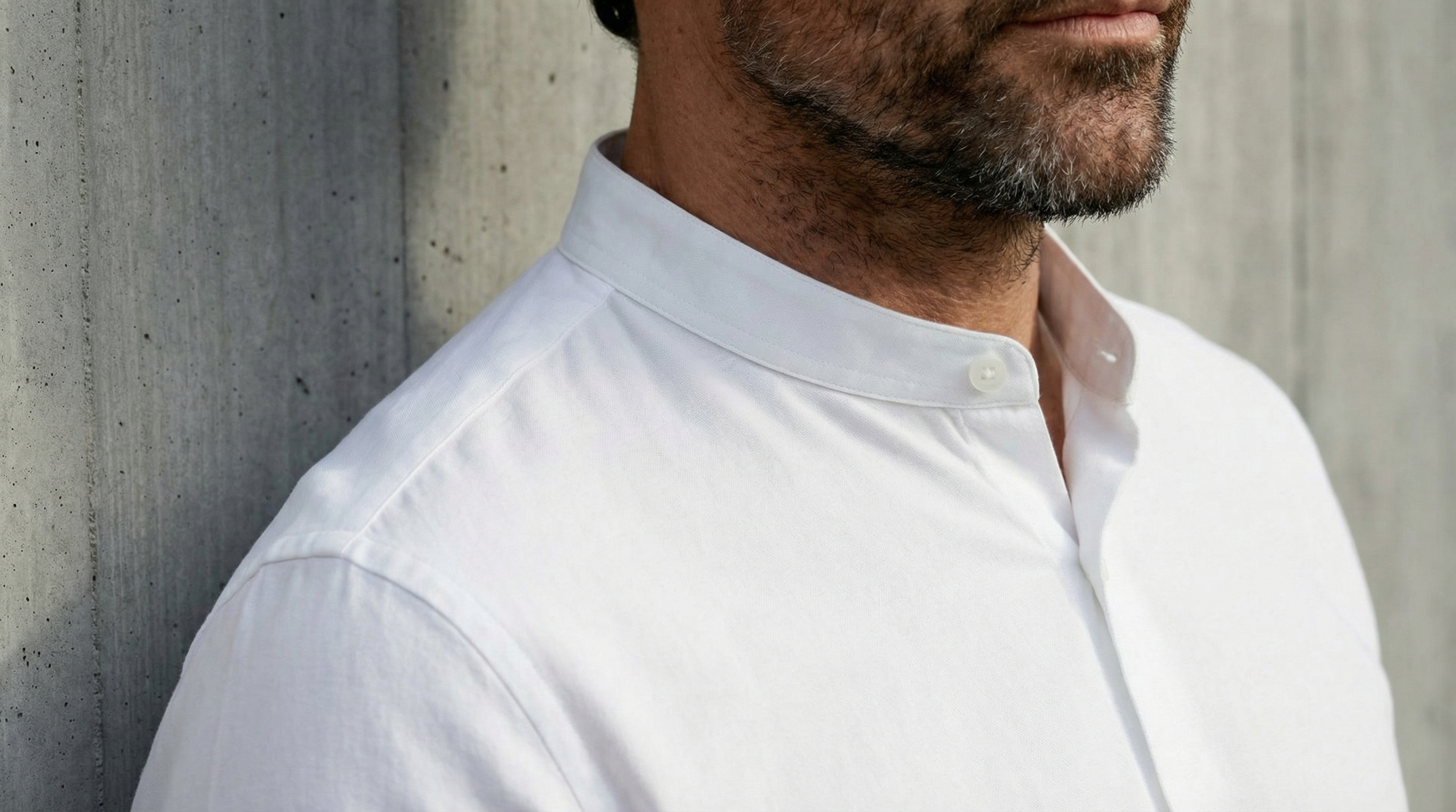 Gros plan sur le col mao structuré d’une chemise blanche stretch pour homme, coupe moderne et épurée.