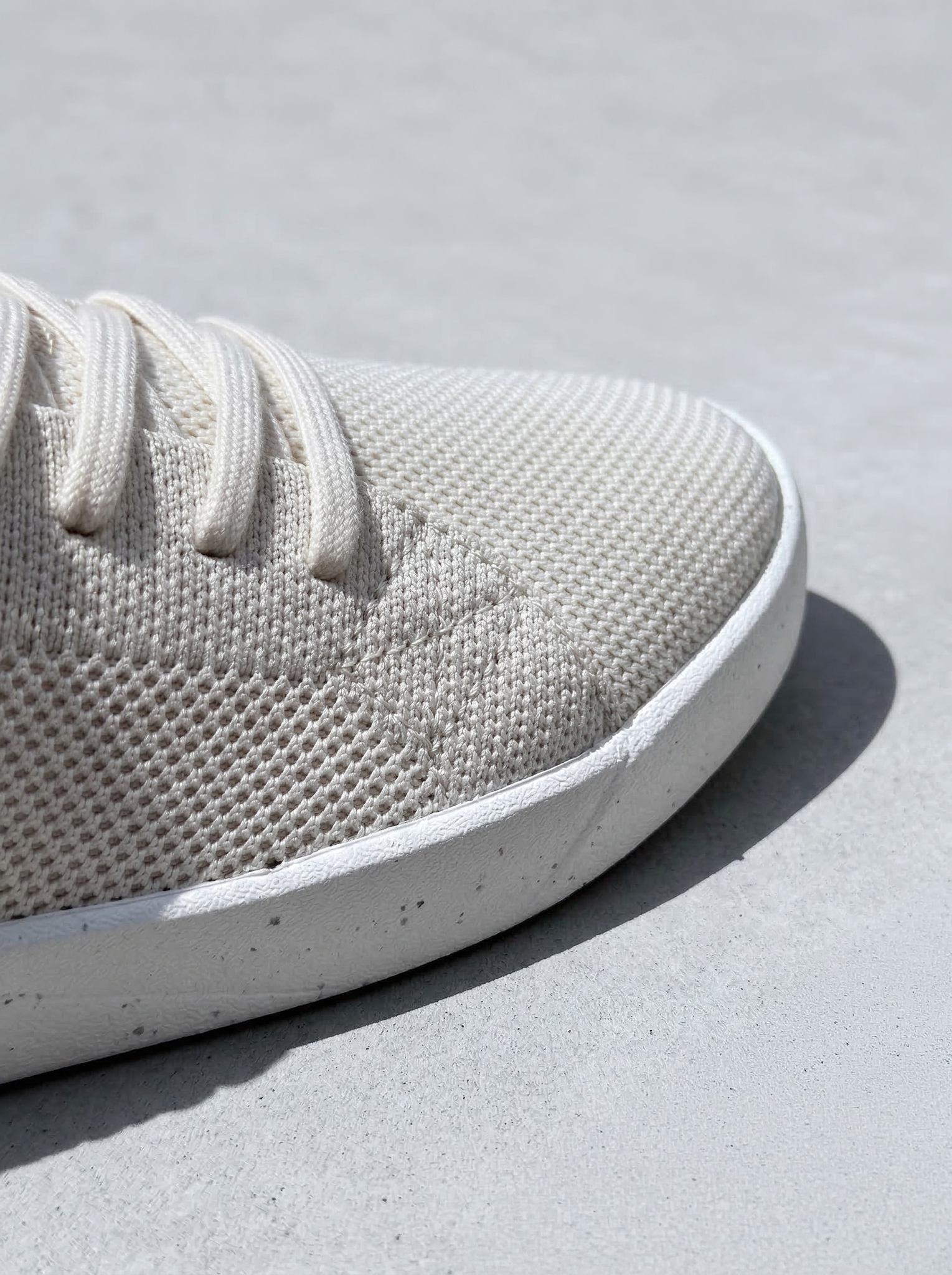 Détail de tige en textile structuré avec couture apparente et semelle minimaliste.