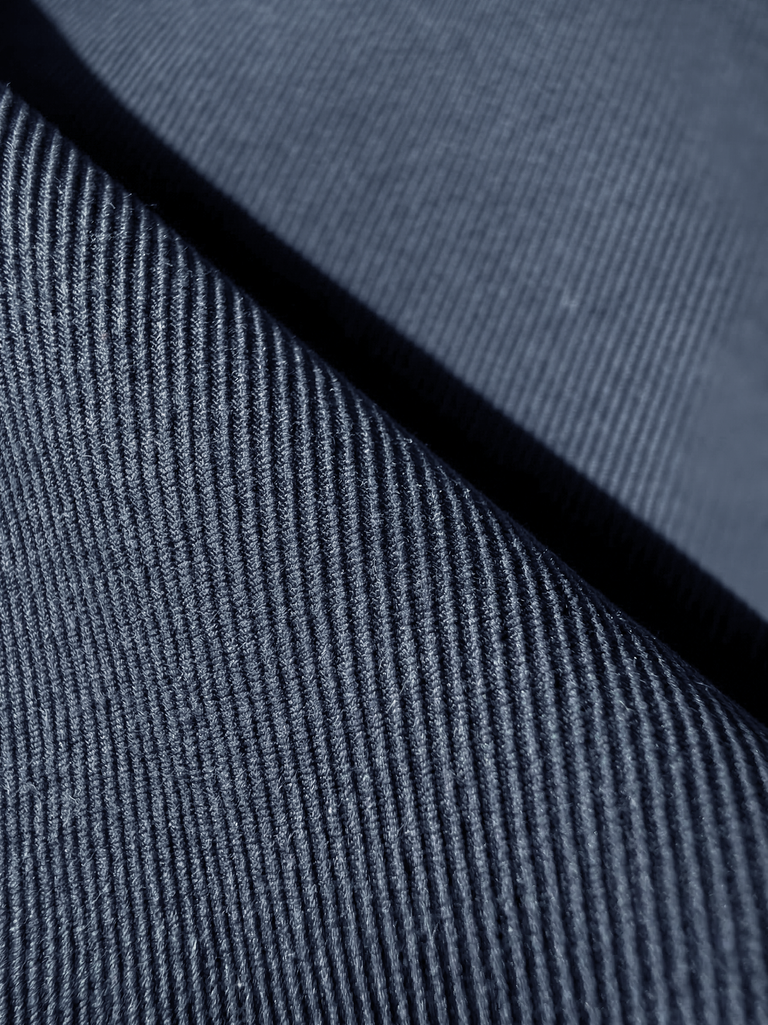 Macro du textile structuré bleu foncé avec relief fin et régulier.