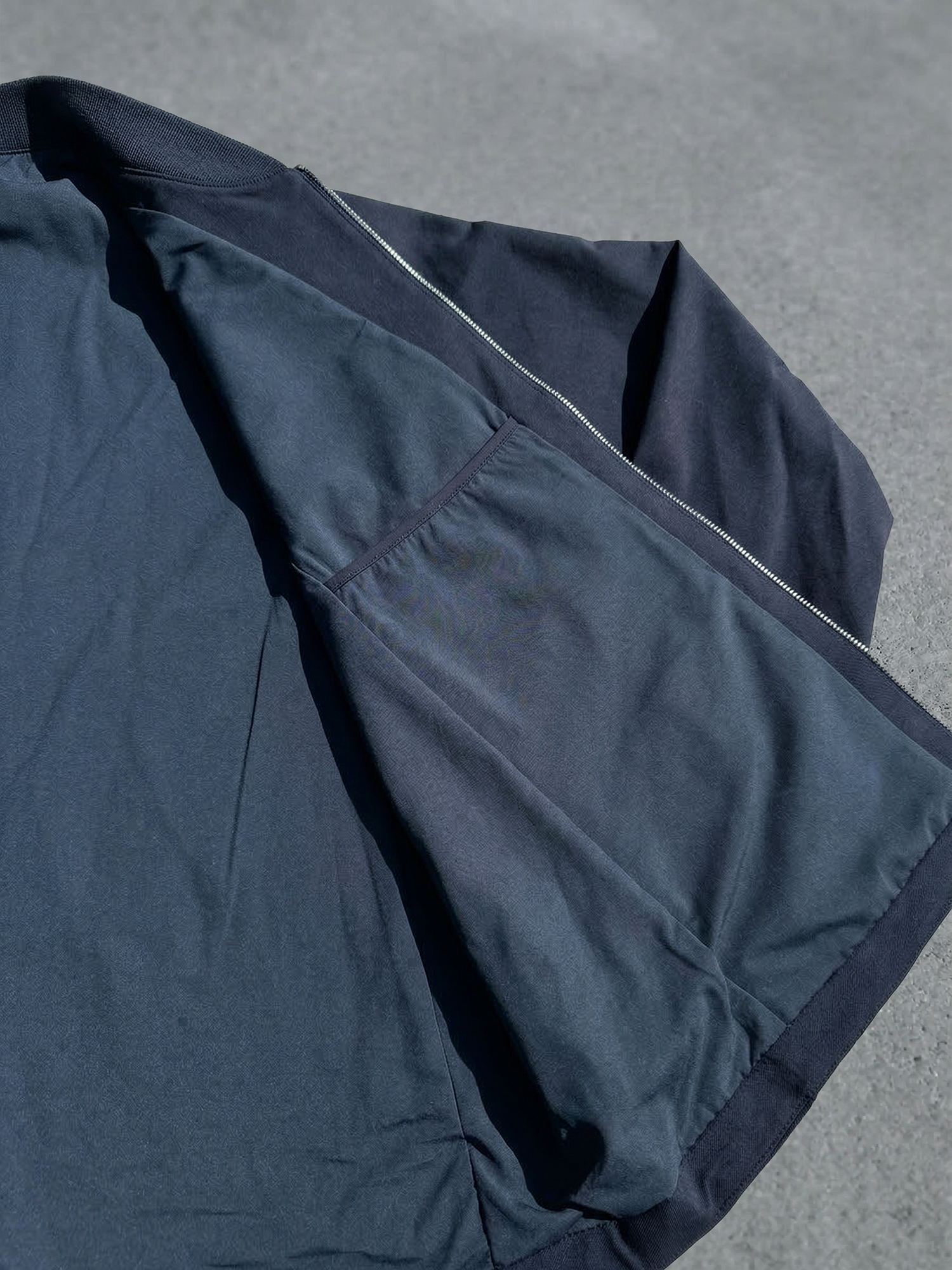 Détail de la doublure et de la poche intérieure avec fermeture éclair sur veste bleu marine.