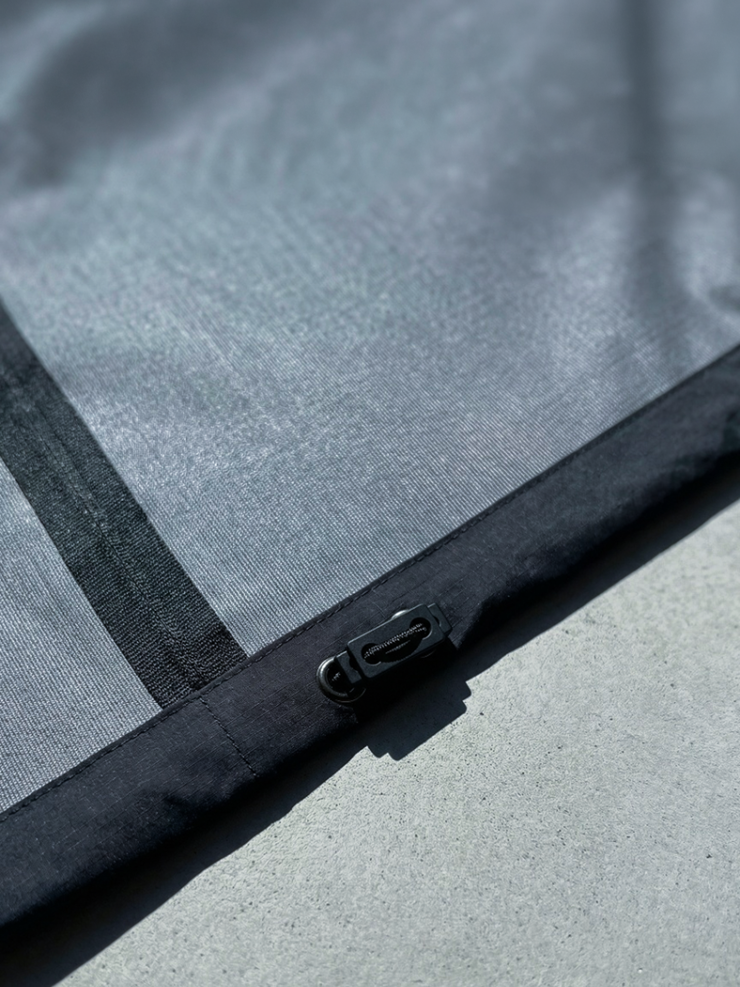 Détail du cordon de serrage réglable sur la veste Ultra Hardshell noir en tissu technique imperméable.
