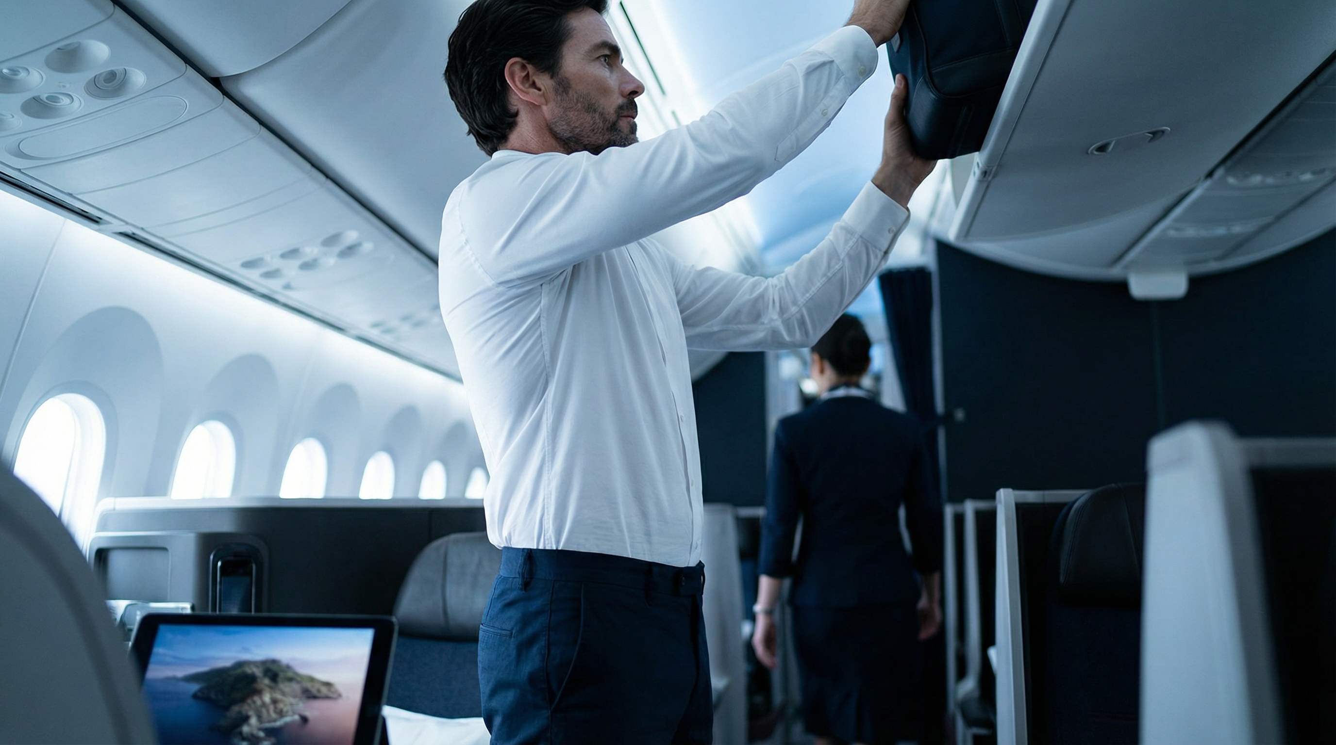Homme portant une chemise blanche stretch ajustée lors d’un déplacement en avion, silhouette élégante et confortable.