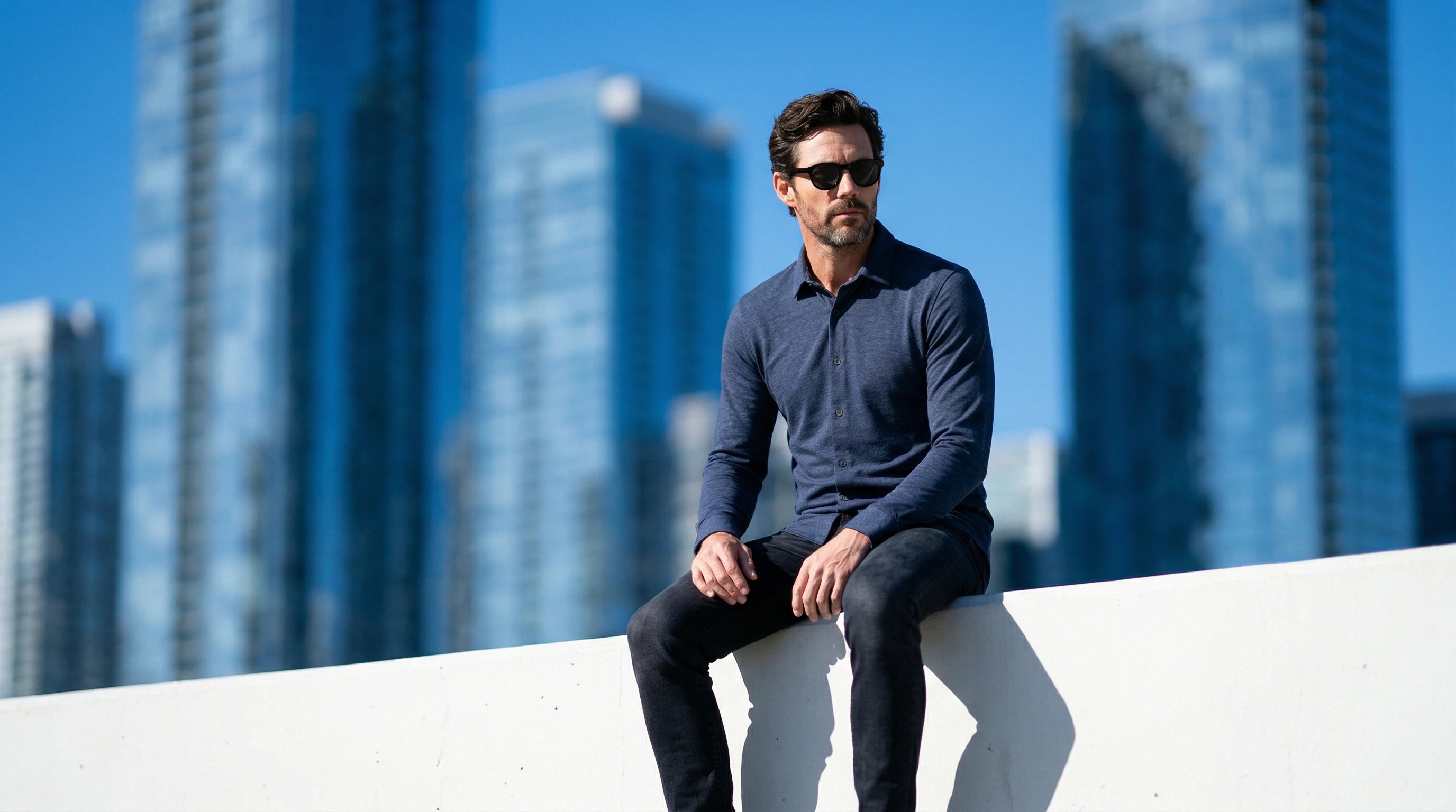 Lunettes de soleil noires portées par un homme dans un environnement urbain contemporain.