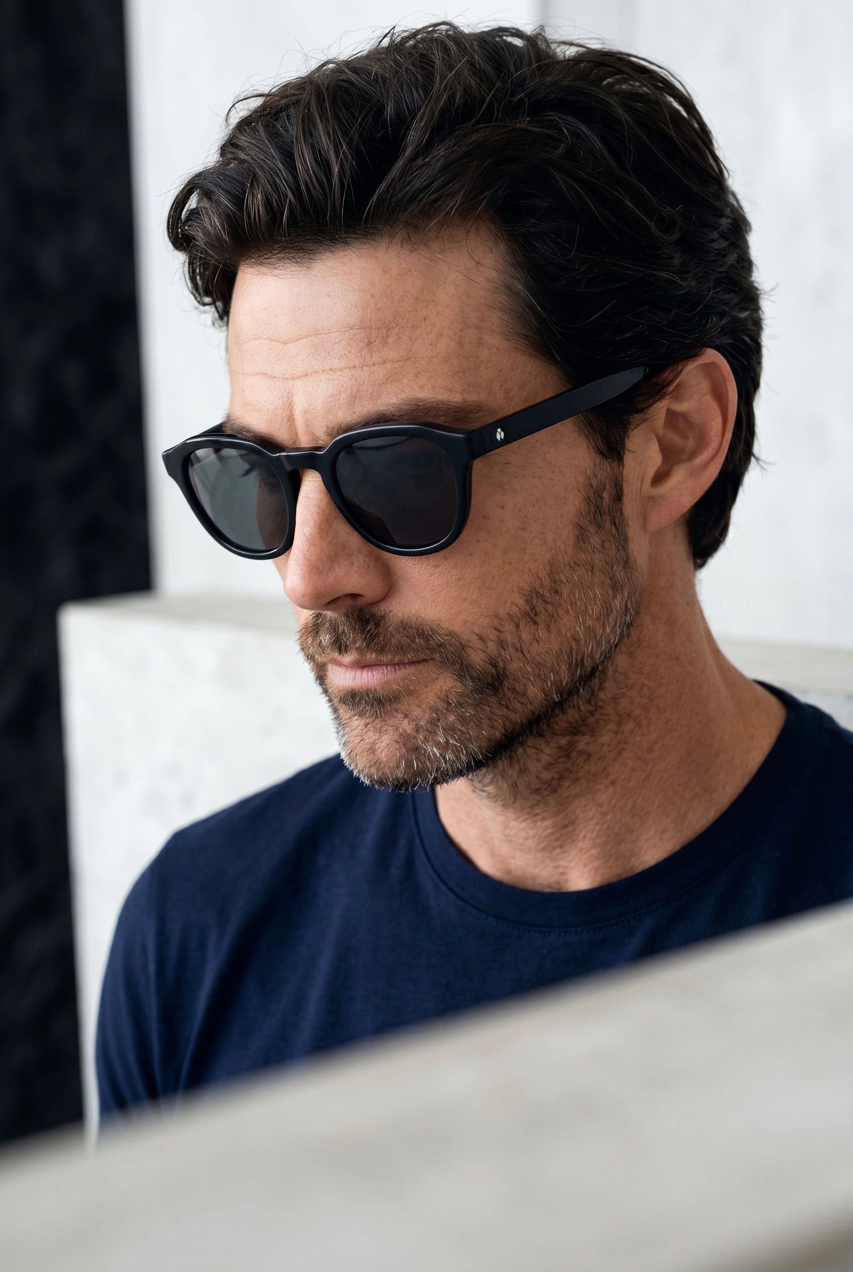 Gros plan sur un homme portant des lunettes de soleil noir translucides au design intemporel.
