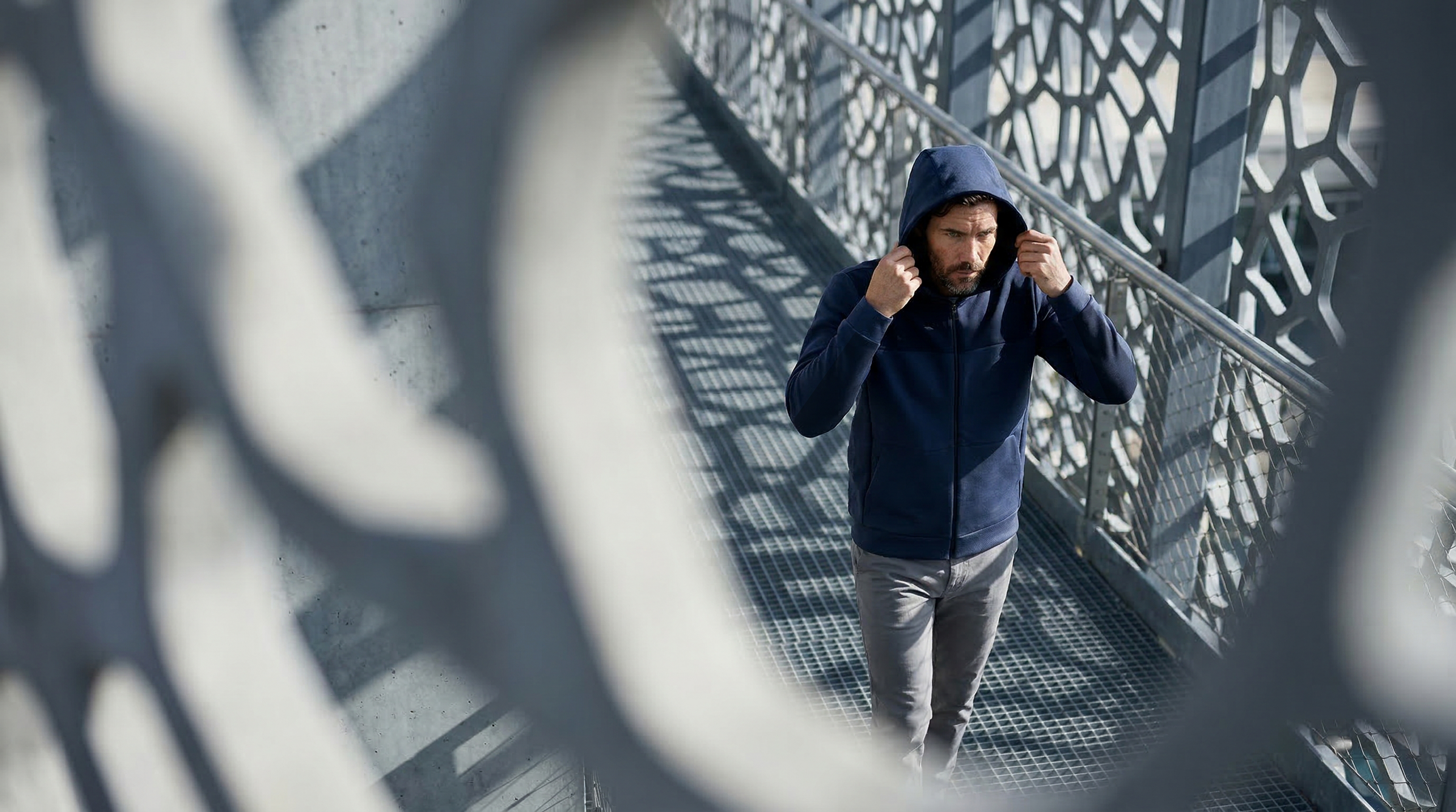 Homme portant un hoodie technique Seagale avec capuche en environnement urbain moderne.