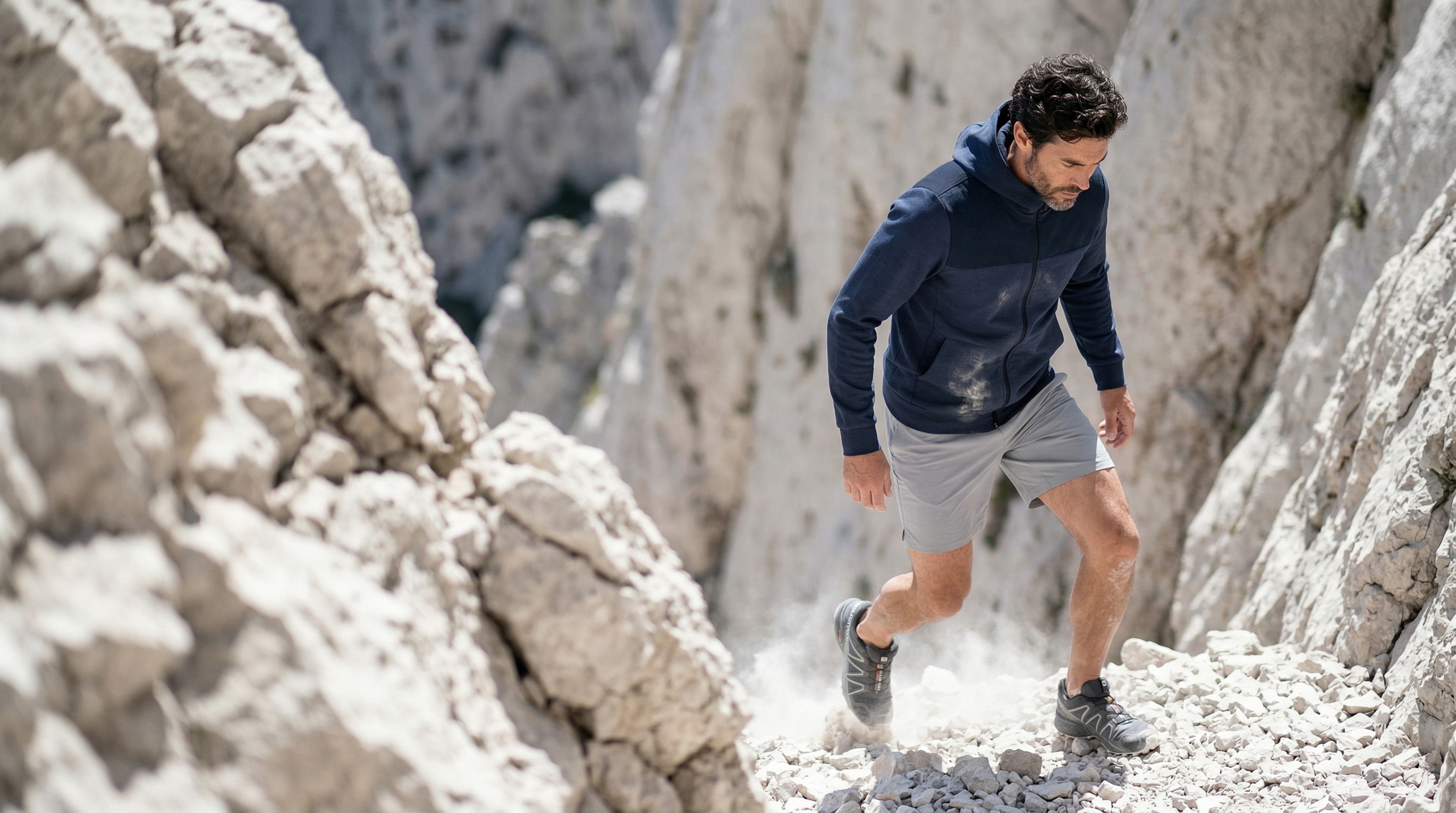 Hoodie technique porté en trail sur terrain rocheux.