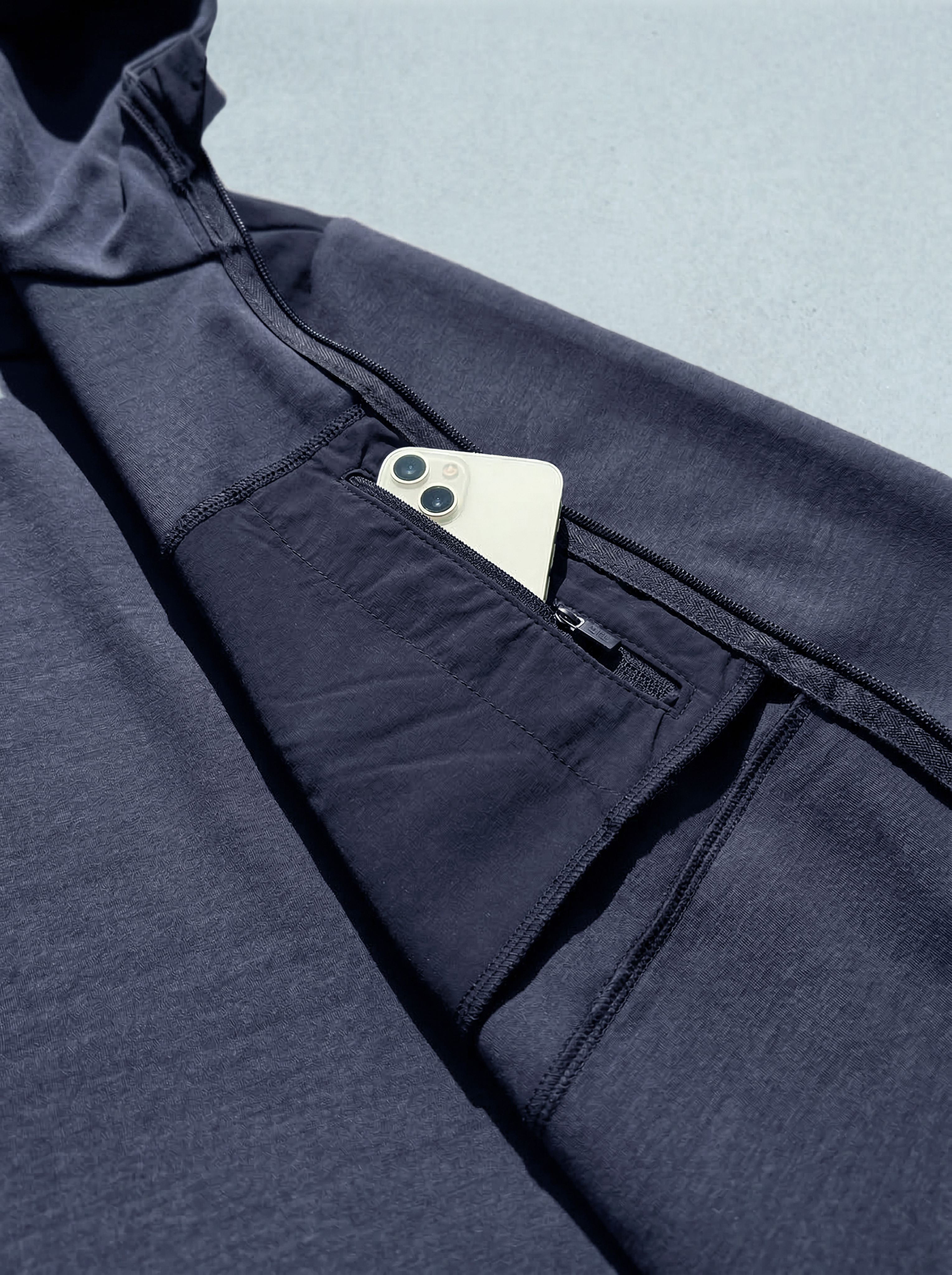 Poche poitrine zippée du hoodie technique bleu marine Seagale avec smartphone.