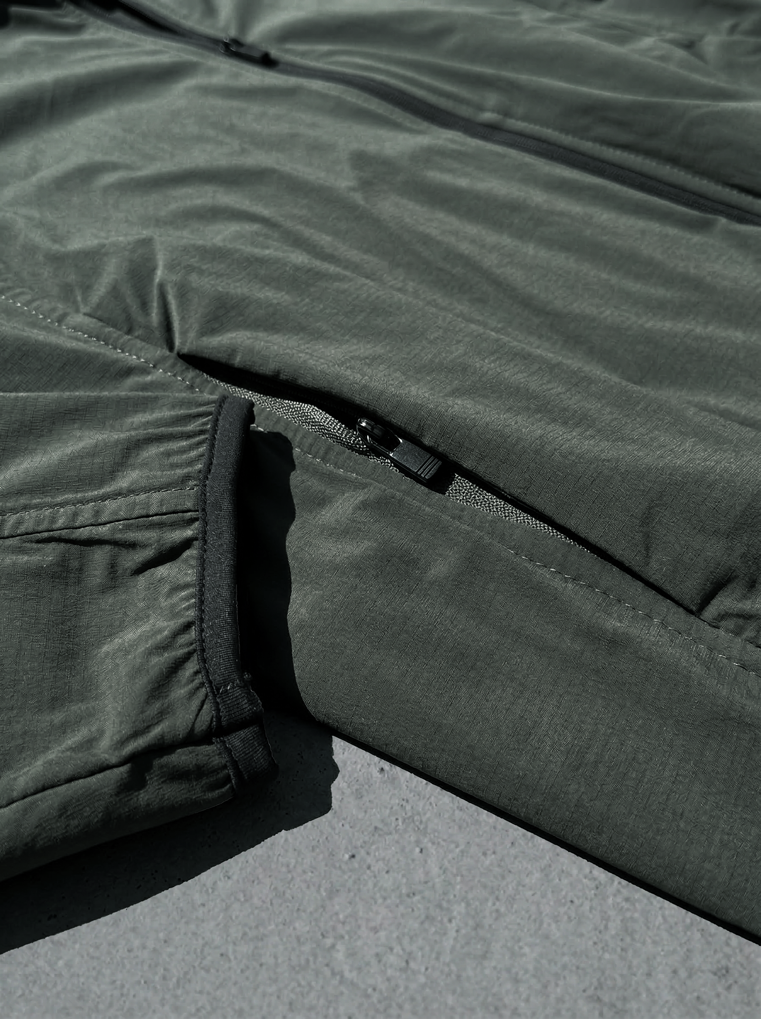 Poche latérale zippée sécurisée sur veste technique vert kaki résistante.
